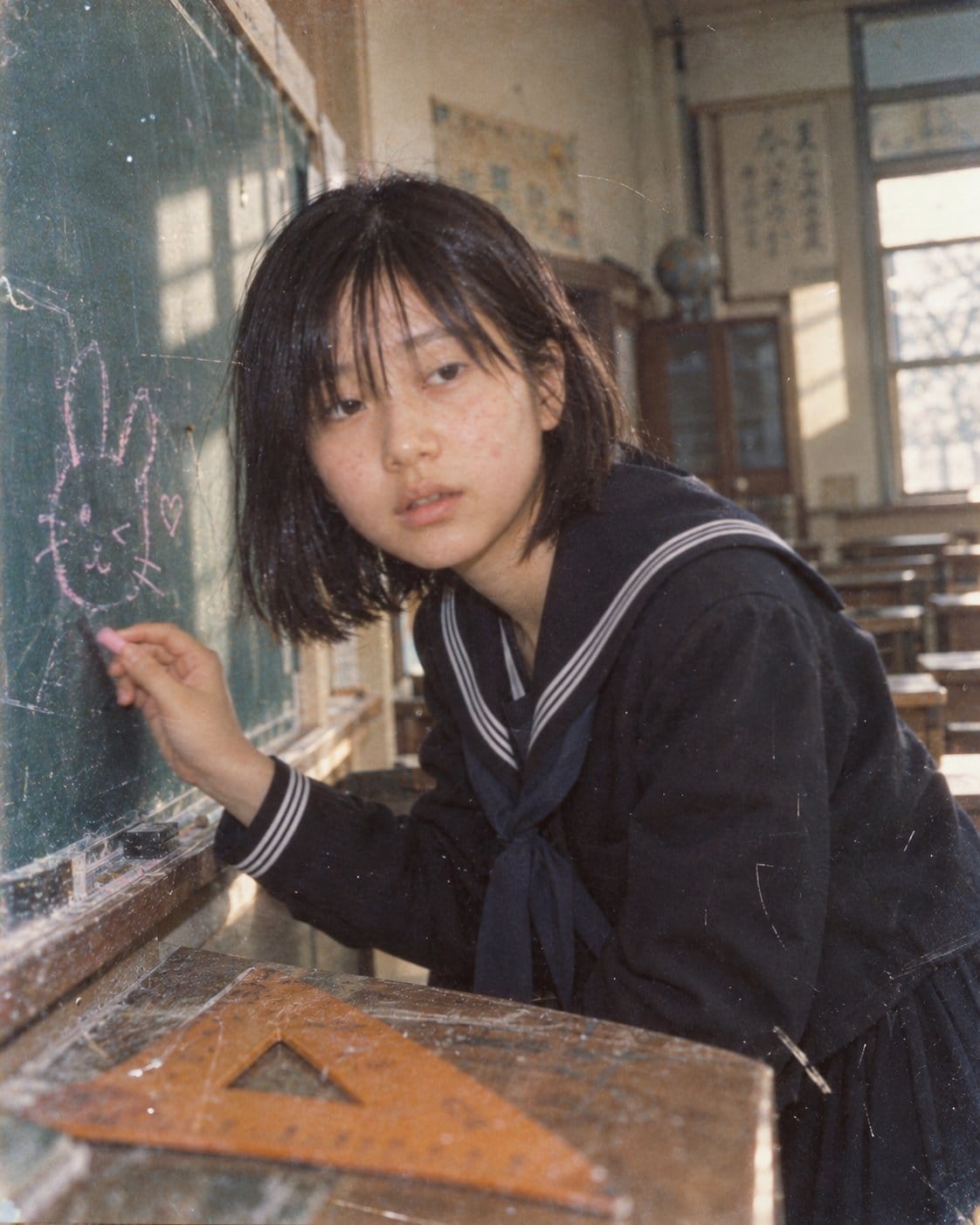 怀旧女学生在黑板上绘画