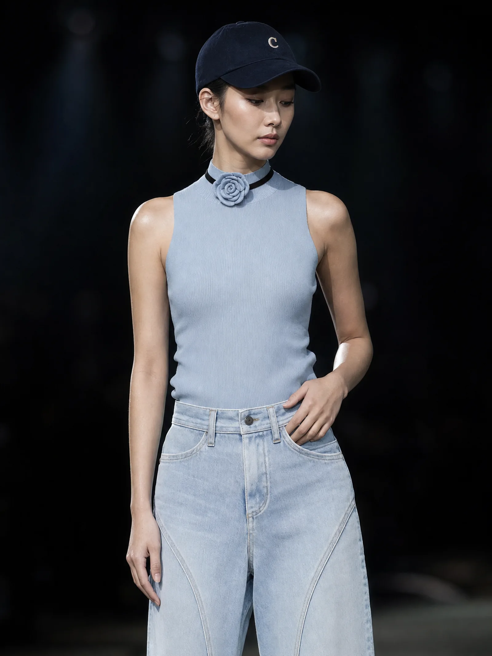 超写实高级时装秀人像摄影，一位20多岁的东亚年轻女性模特站在昏暗的大型T台或舞台